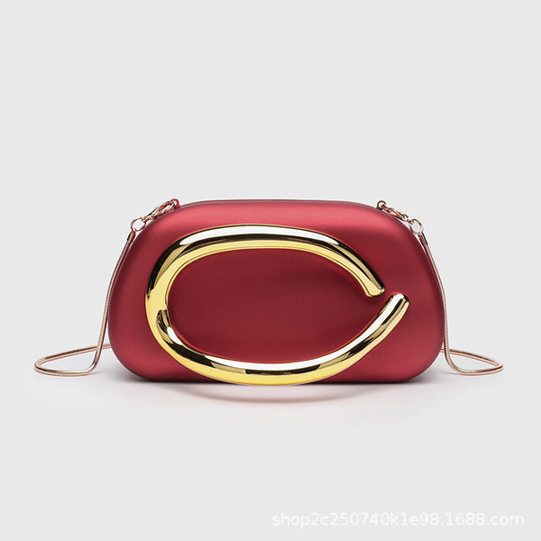Kleine rechteckige Crossbody-Clutch mit abgerundeten Ecken, oversized poliertem C-förmigem Goldgriff und schmalem Goldkettenriemen, Detailansicht