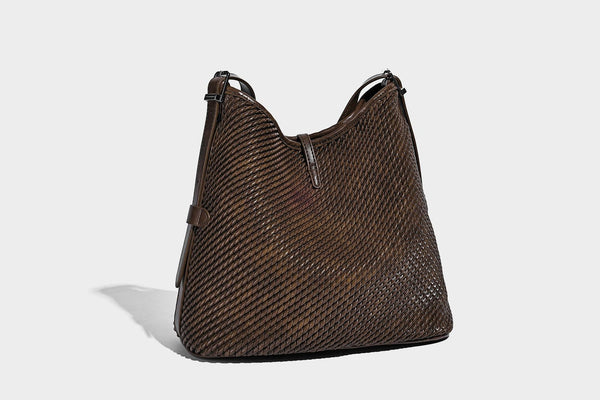Große Schultertasche in Beutelform mit Flechtoptik, glatten Besätzen in Lederoptik, verstellbarem Riemen und hängendem Anhänger-Detail, Detailansicht