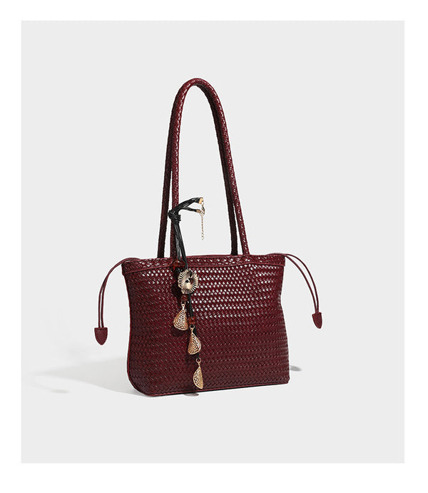 Structured woven leather-look tote bag in dark brown with long shoulder straps, side drawstring ties, and gold filigree