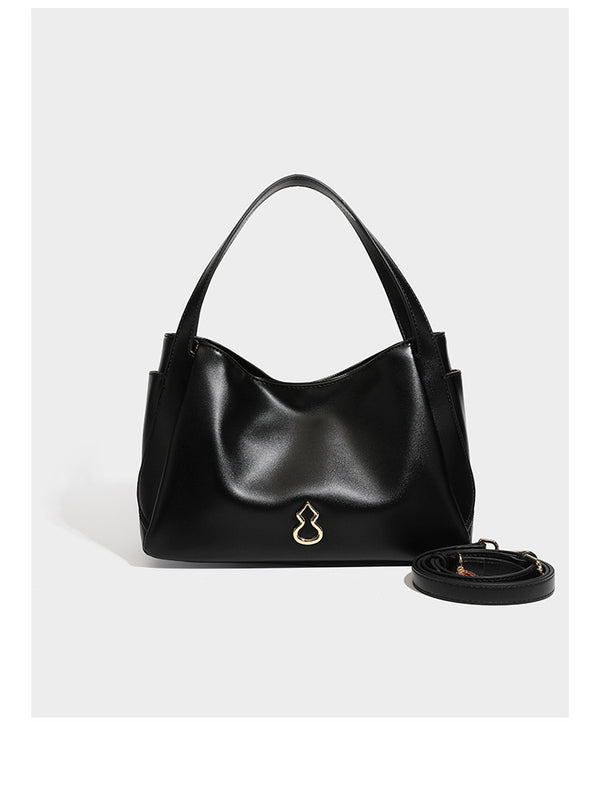 Structured glossy leather-look tote shoulder bag with dual top handles, detachable crossbody strap, side pockets, and, detail