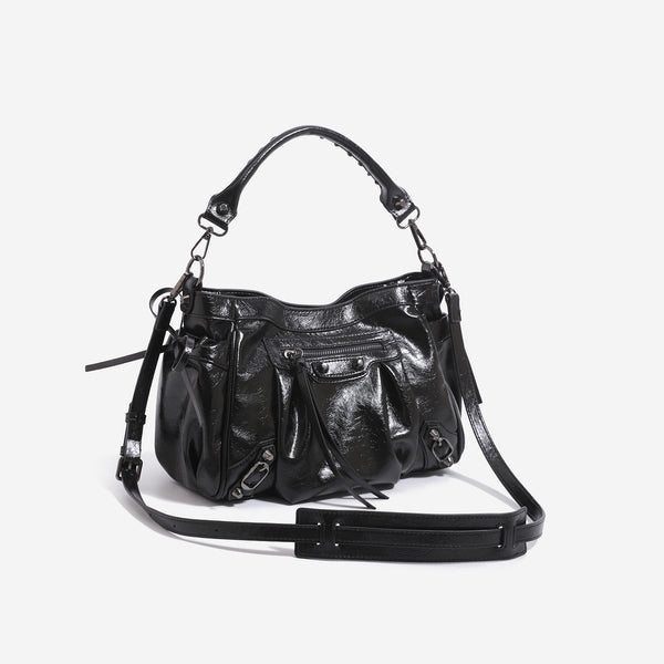 Glossy ruched leather-look shoulder bag with silver stud hardware, fringe trim, front zip pocket, and top handle, detail view