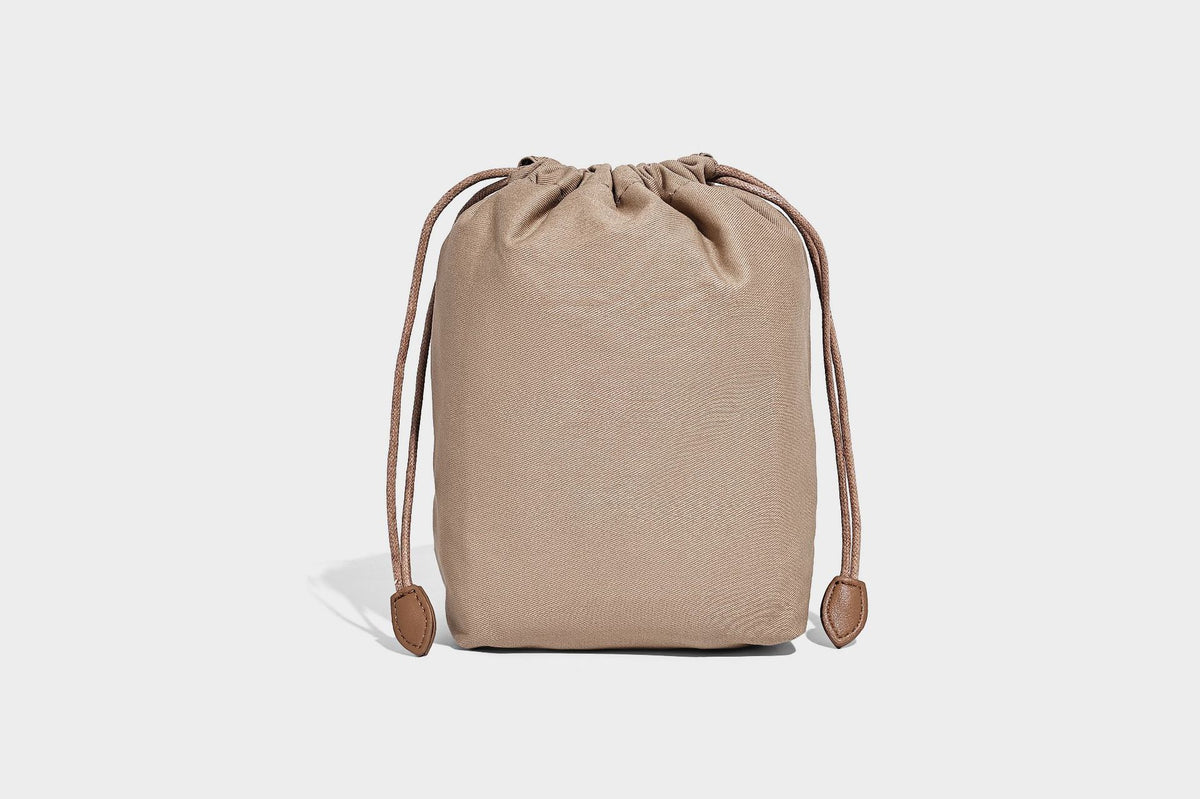 Small woven lattice bucket bag in tan and cream leather-look strips with drawstring top and detachable crossbody strap