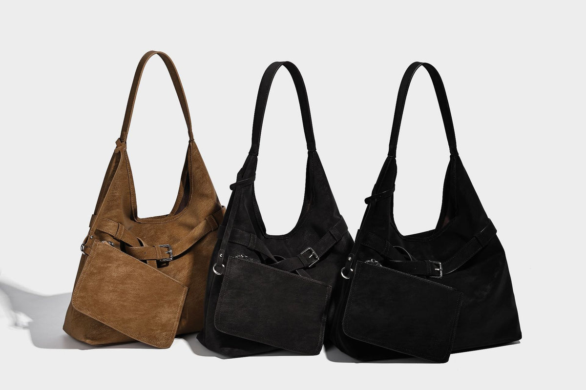 Slouchy oversized shoulder tote bag with matte textured finish, wrap-around buckle strap, and detachable front zip pouch