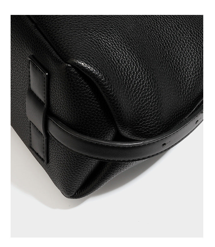 Slouchy hobo shoulder bag with pebbled leather-look finish, zip-top closure, gold-tone hardware, and hanging bead charm