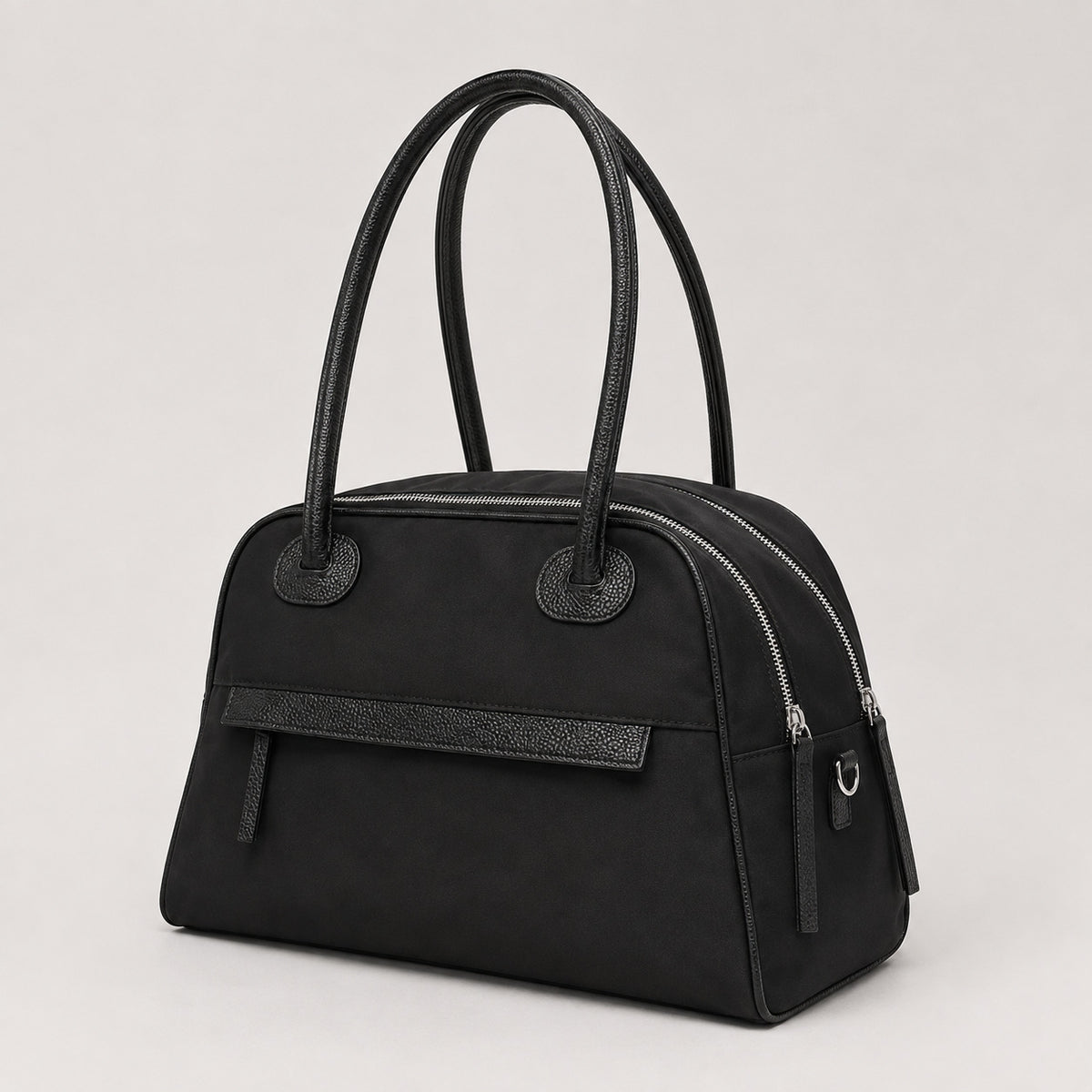 Structured dome top-handle bag in matte nylon with pebbled vegan leather-look trim, zip-top closure, front slip pocket, and