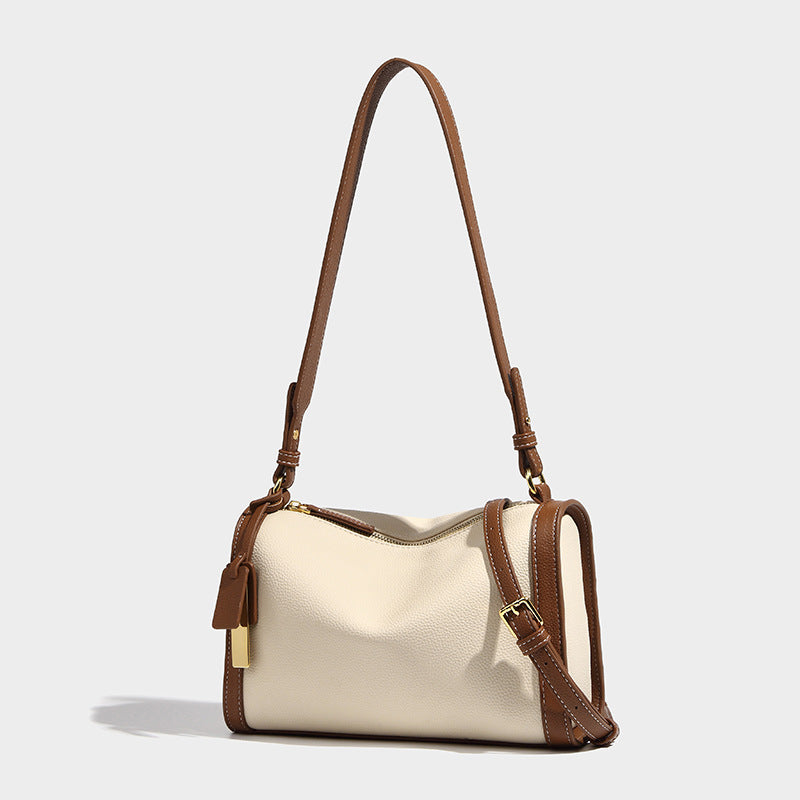 Structured two-tone shoulder bag with pebbled leather-look finish, contrast trim, top zip closure, and gold-tone hardware