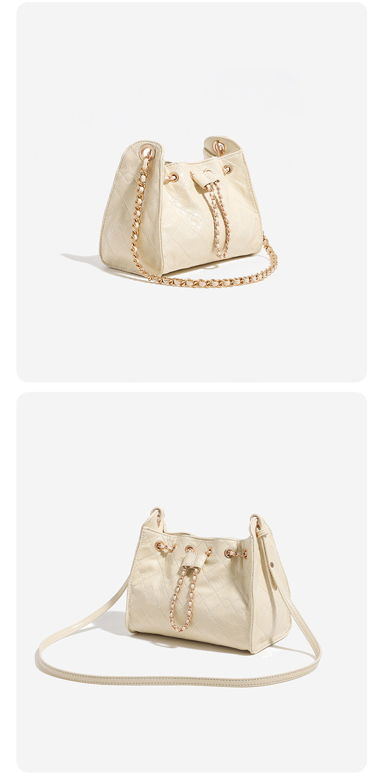 Glossy diamond-quilted drawstring bucket bag with gold-tone chain strap and eyelet hardware, detail view 11