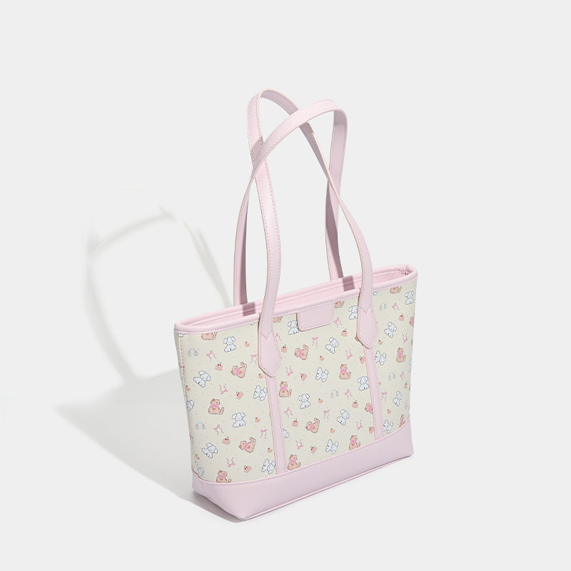 Große, strukturierte Tote-Bag mit Reißverschluss oben, Einsätzen mit pastellfarbenem Cartoon-Print, glattem Besatz in rosafarbener Lederoptik und zwei Schulterriemen