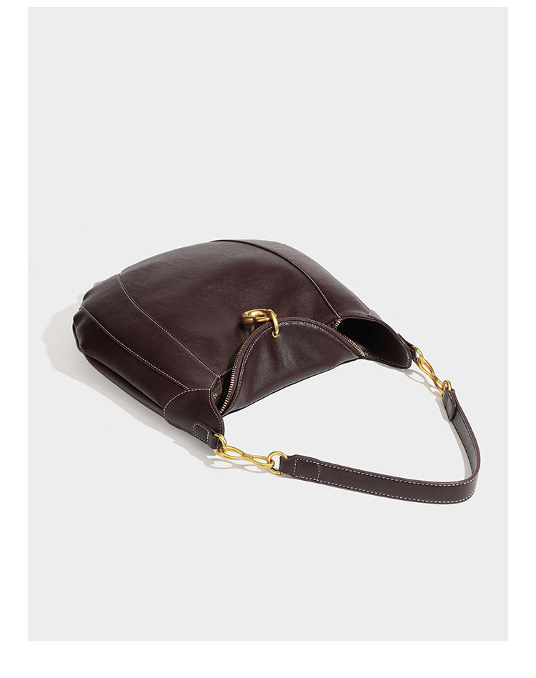 Locker fallende Hobo-Schultertasche in Halbmondform in Dunkelbraun mit goldfarbenem Ring und Kettenglied-Details sowie Reißverschluss oben, Detailansicht