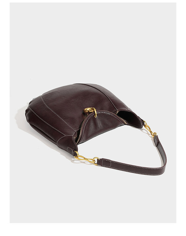 Locker fallende Hobo-Schultertasche in Halbmondform in Dunkelbraun mit goldfarbenem Ring und Kettenglied-Details sowie Reißverschluss oben, Detailansicht