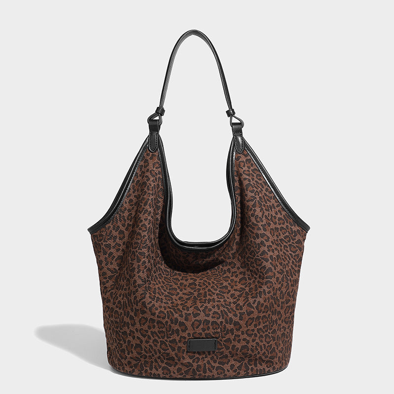 Slouchy brown leopard jacquard hobo tote bag with black leather-look trim and single shoulder strap, shown with black, detail