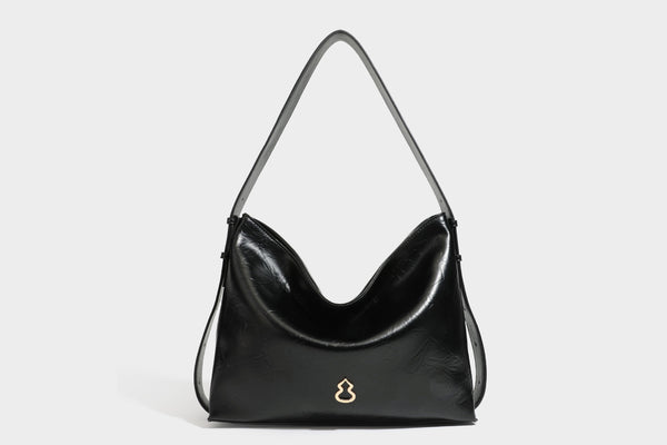 Lässig fallende Hobo-Schultertasche mit offenem Oberteil aus glänzender, karamellbrauner Lederoptik, mit Logo-Beschlägen in Goldoptik und langem, verstellbarem