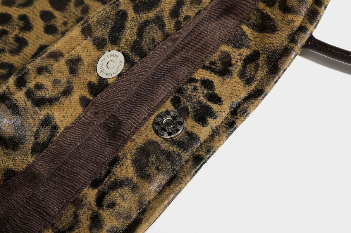 Large leopard print shoulder tote bag in tan and brown with slim dark straps and dangling beaded charm hardware, detail view