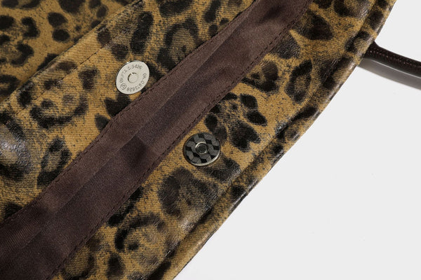 Large leopard print shoulder tote bag in tan and brown with slim dark straps and dangling beaded charm hardware, detail view