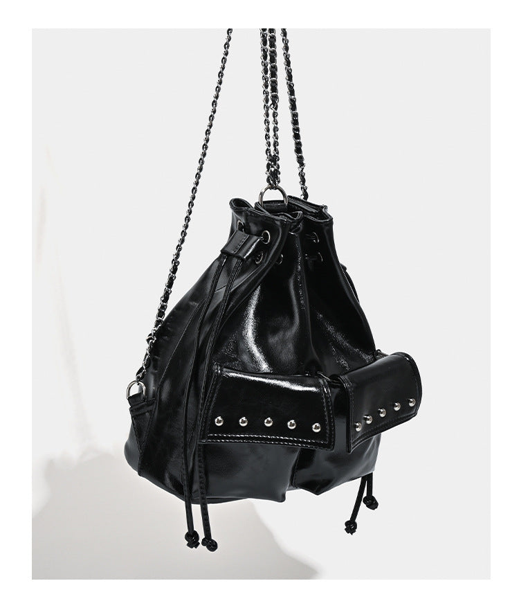 Glossy leather-look drawstring bucket bag with silver dome studs and chain shoulder strap, detail view 11