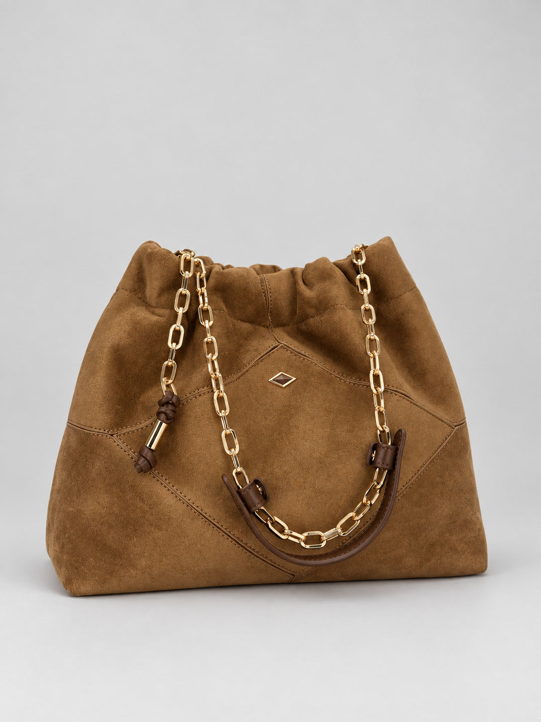 Slouchy suede-look shoulder bag with gathered top, angular stitched paneling, and chunky gold-tone chain strap, detail view