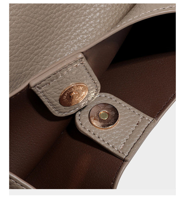 Schultertasche in genarbter Lederoptik im Hobo-Stil mit goldfarbener Kette, kurzem Tragegriff und dekorativem Anhänger an der Seite, Detailansicht