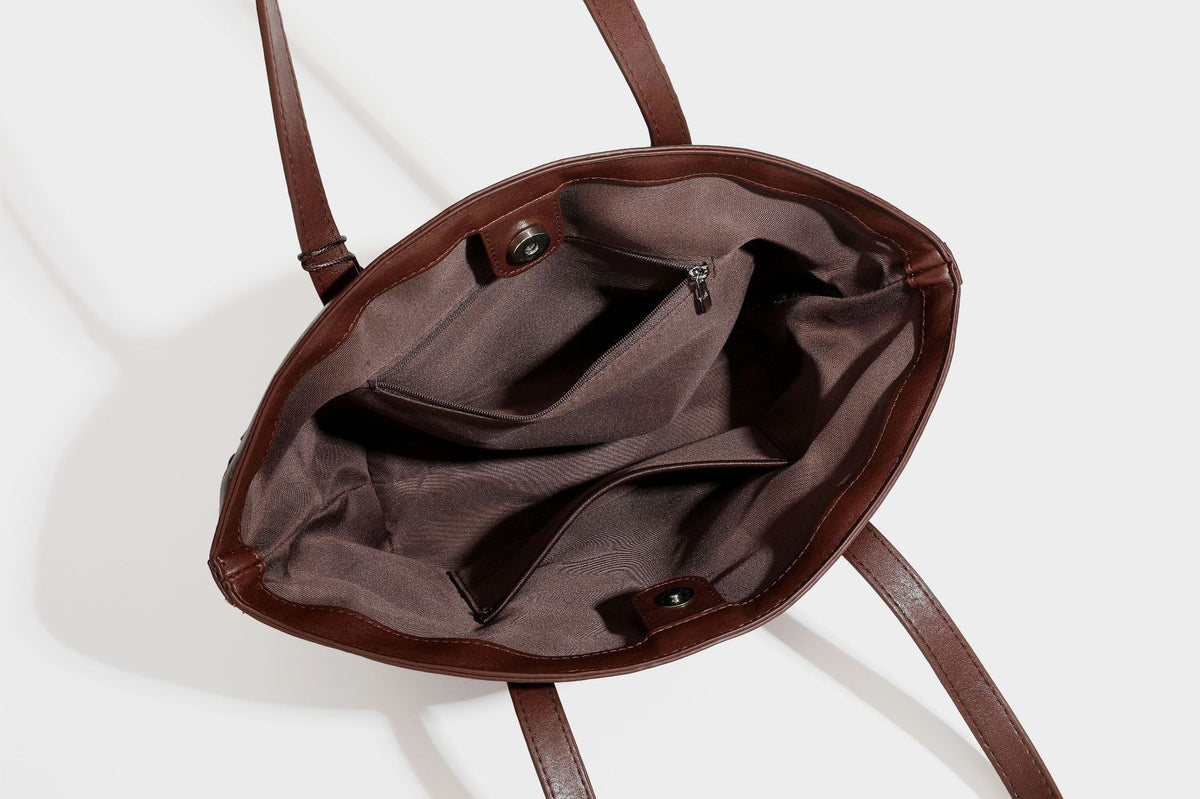 Large leather-look tote bag with geometric woven emboss, double shoulder straps, and round woven cord charm in brown, detail