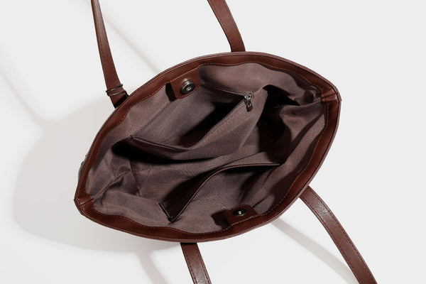 Large leather-look tote bag with geometric woven emboss, double shoulder straps, and round woven cord charm in brown, detail