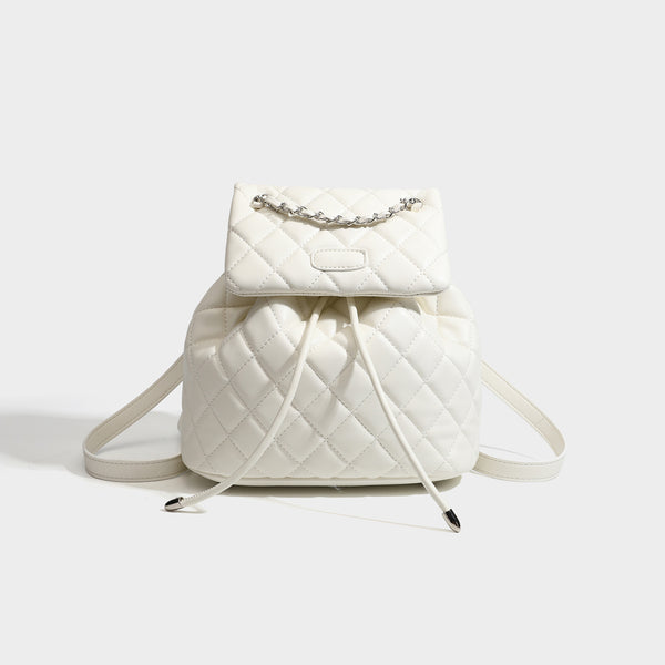 Black diamond-quilted backpack handbag with silver-tone chain flap accent and adjustable shoulder straps, detail view 7