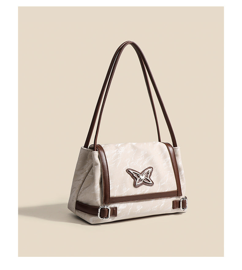 Structured crinkle-finish flap shoulder bag with butterfly metal appliqué and dark brown contrast trim, detail view 12