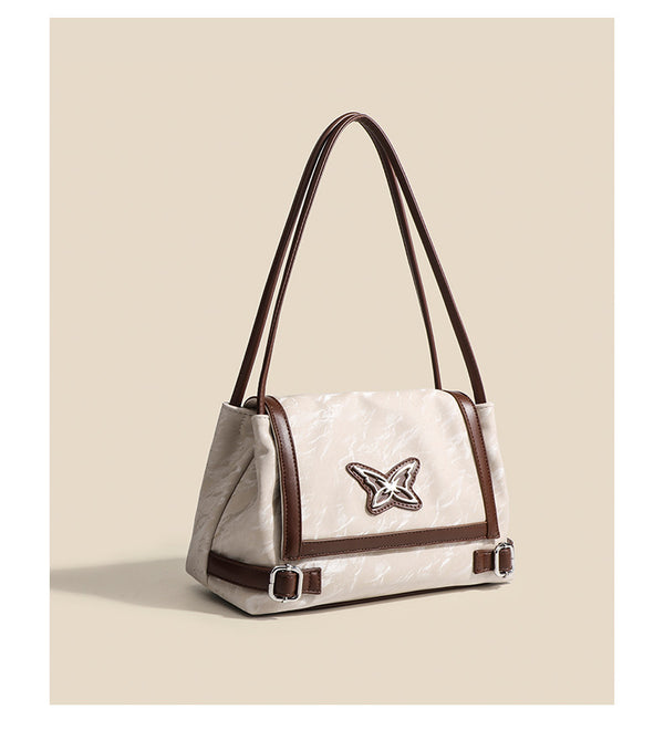 Structured crinkle-finish flap shoulder bag with butterfly metal appliqué and dark brown contrast trim, detail view 12