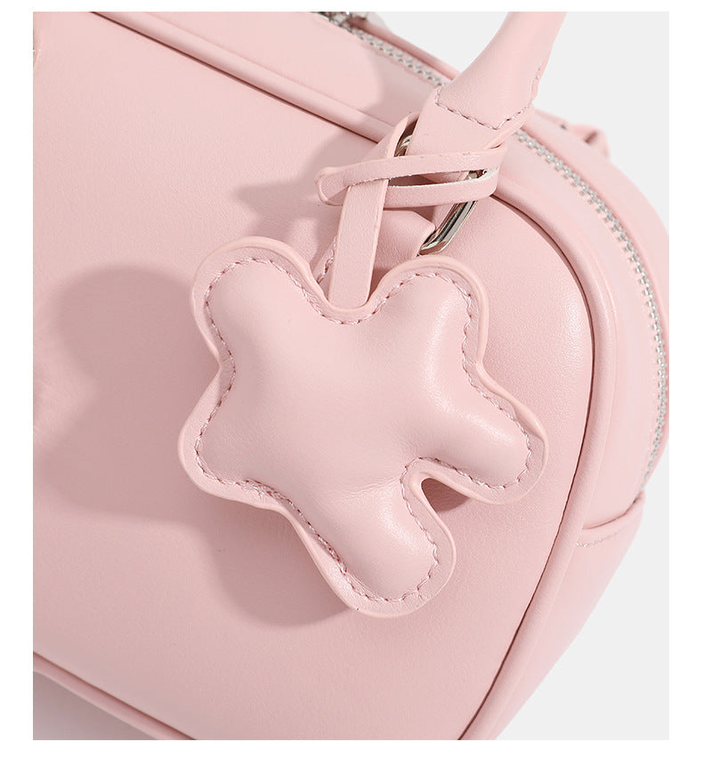 Small structured rounded-rectangle mini handbag with glossy leather-look finish, top zip closure, silver-tone hardware, and