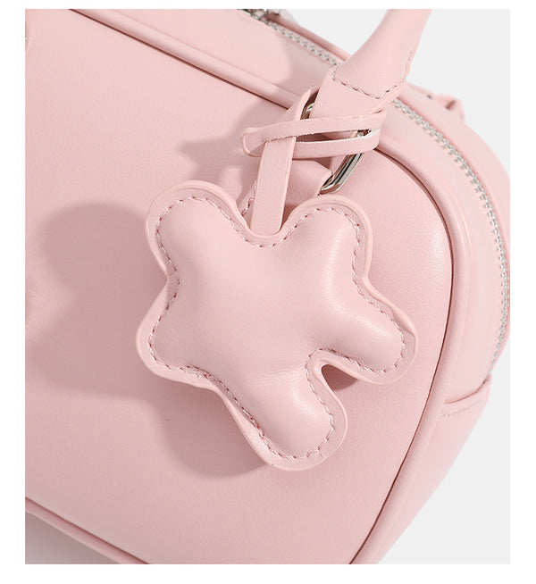 Small structured rounded-rectangle mini handbag with glossy leather-look finish, top zip closure, silver-tone hardware, and