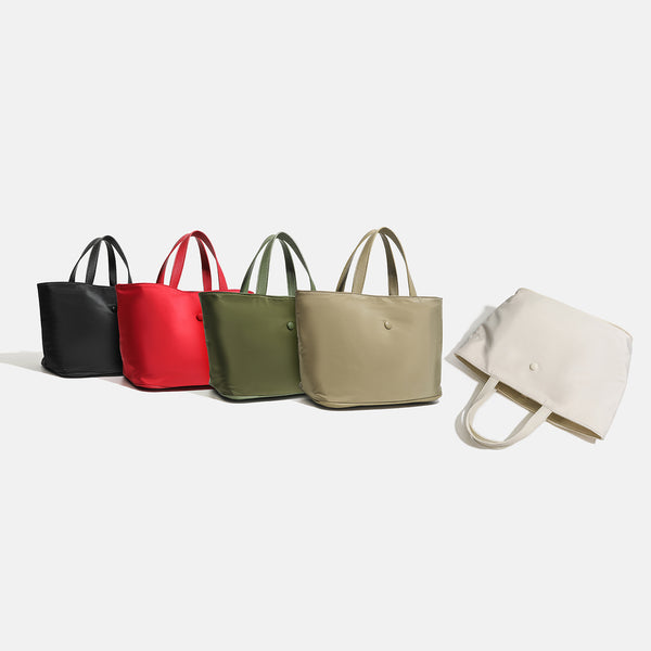 Structured lightweight nylon tote bag with textured double top handles and snap-button front detail, detail view 2