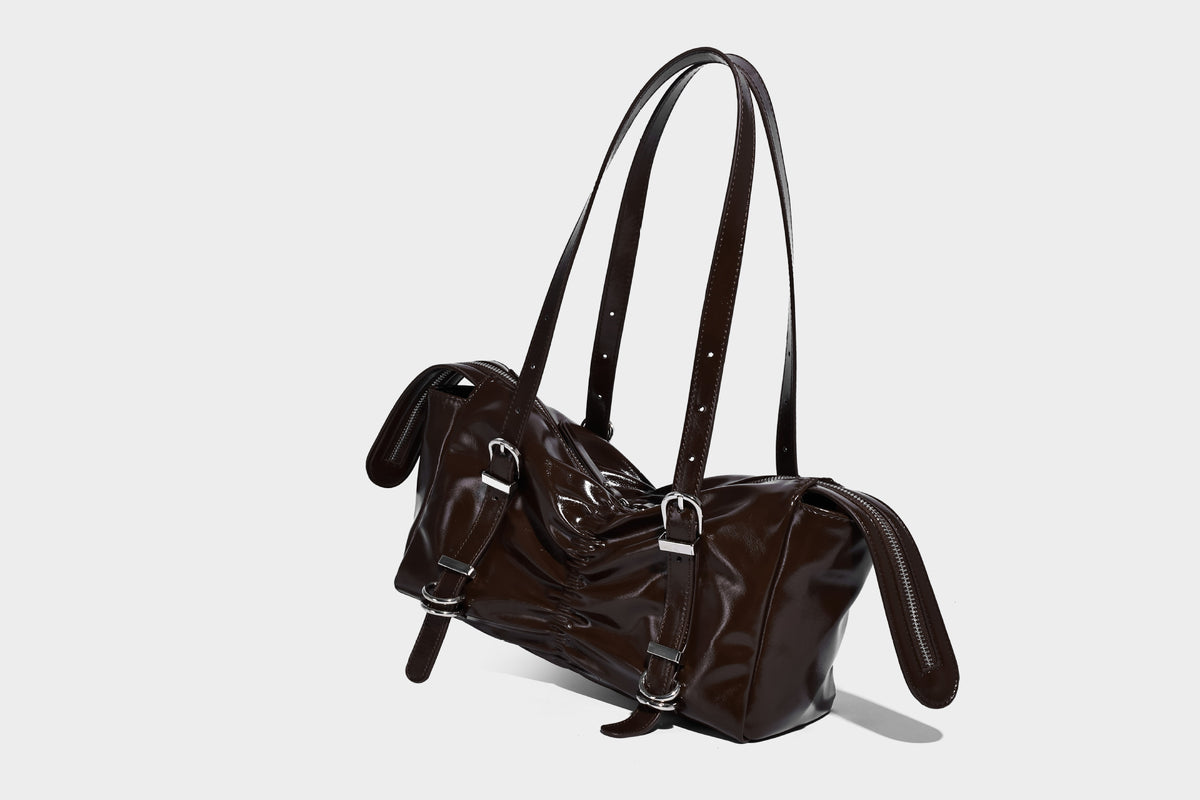 Glänzende, rechteckige Schultertasche mit Raffdetails, zwei verstellbaren Riemen, Reißverschluss oben und Schnallenbeschlägen in Silberoptik