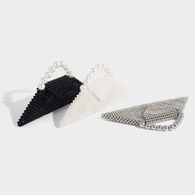 Small structured triangle clutch bag covered in glossy pearl beads with an arched pearl top handle and silver snap closure