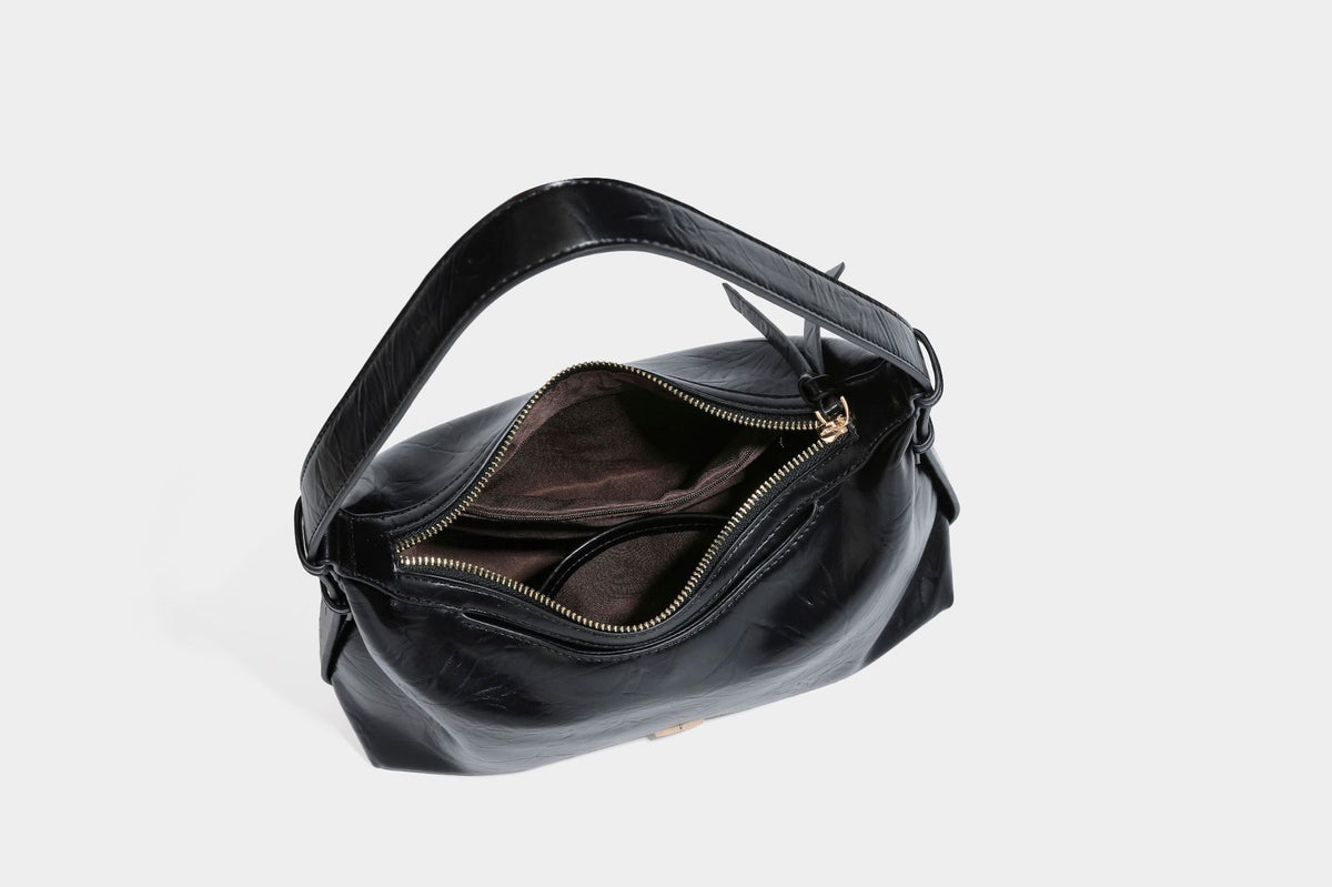 Übergroße, lässig fallende Hobo-Schultertasche aus glänzendem, geknittertem Material in Lederoptik mit Reißverschluss und Emblem-Beschlägen in Goldoptik, Detailansicht