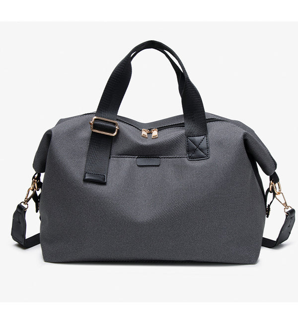 Structured woven duffel bag with dual tan webbing handles, detachable shoulder strap, top zip closure, and gold-tone