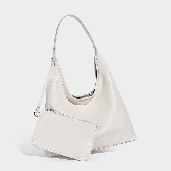 Slouchy hobo shoulder bag in pale yellow glossy pebbled leather-look finish with single shoulder strap and detachable front
