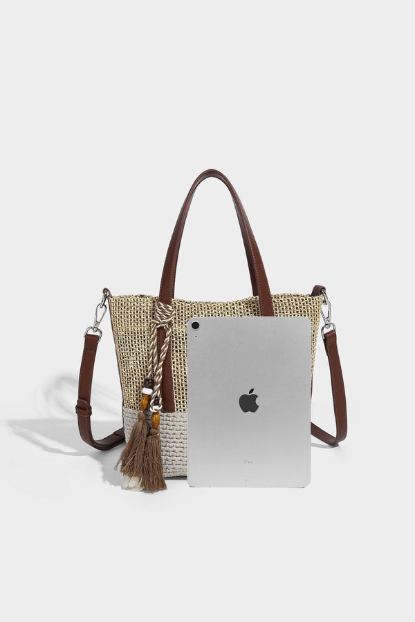 Two-tone open-weave tote bag in beige and cream with brown leather-look handles, tassel bead charm, and detachable