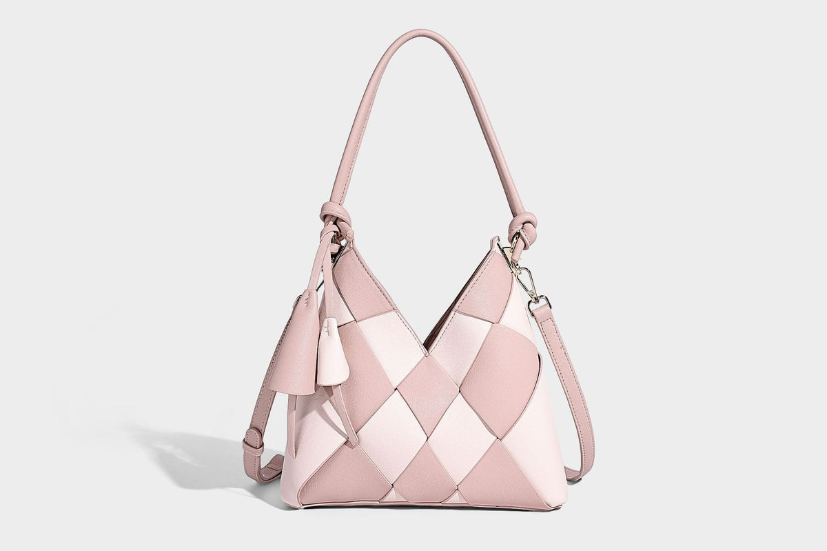 Compact bucket shoulder bag with black-and-white diamond patchwork panels, knotted top handle, gold-tone hardware, and