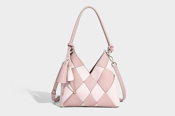Compact bucket shoulder bag with black-and-white diamond patchwork panels, knotted top handle, gold-tone hardware, and