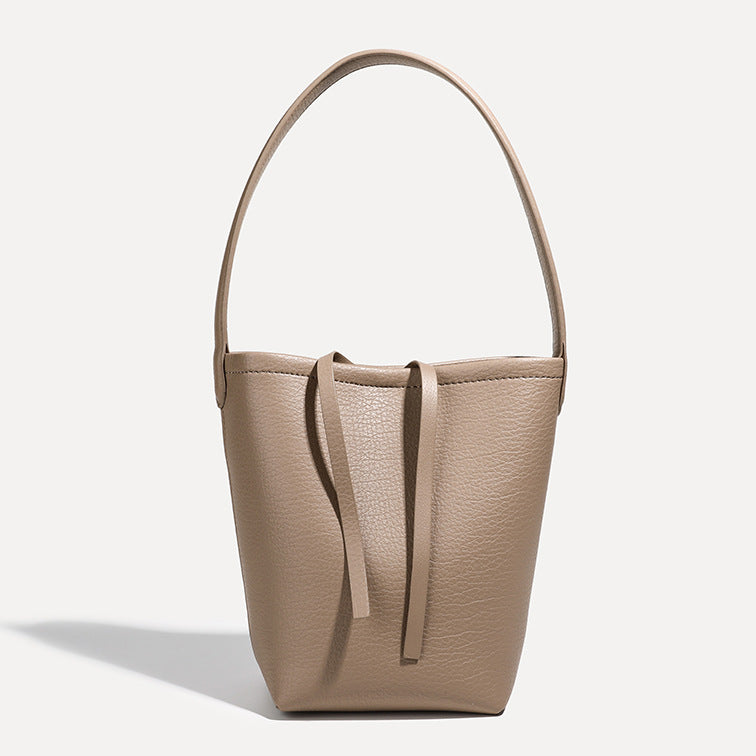 Mini tapered bucket bag in pebbled leather-look finish with front tie straps and single shoulder strap, detail view 9