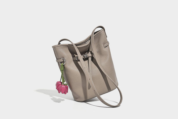 Small pebbled leather-look bucket bag with front drawstring toggle hardware and long adjustable shoulder strap, detail view