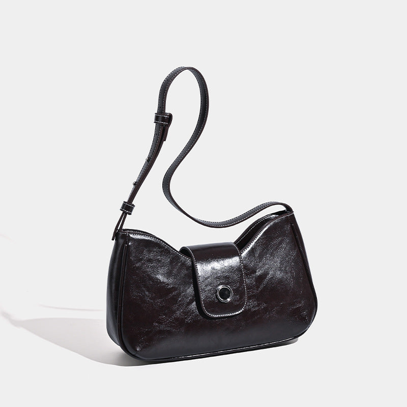 Compact glossy leather-look shoulder bag with round metal snap closure and contrast stitching, detail view 3