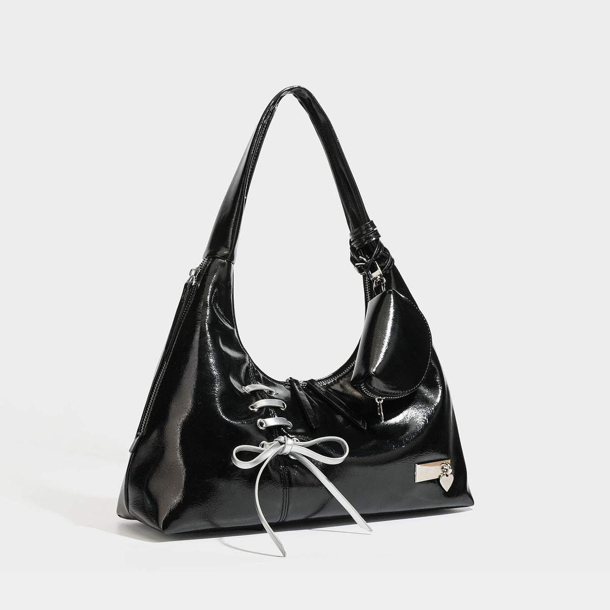 Weich fallende Hobo-Schultertasche mit glänzender Oberfläche in Lederoptik, silberfarbenen Schnürringösen und Schleife aus Ripsband auf der Vorderseite, Detail