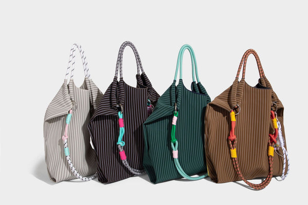 Slouchy pinstripe tote bag with braided rope handles, metal ring hardware, and colorful knotted rope charm, detail view 39