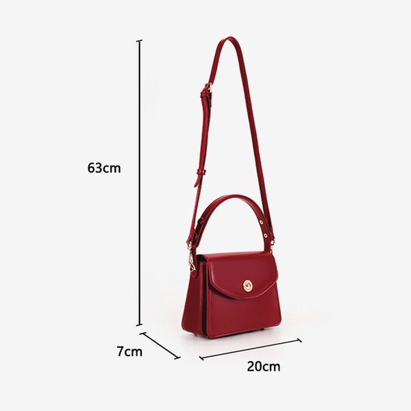 Kleine strukturierte Henkeltasche mit Überschlag in tiefem Rot, glatter Lederoptik, goldfarbenem Drehverschluss, kurzem Henkel und