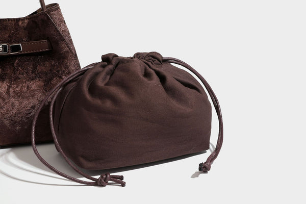 Small structured bucket satchel in embossed velvet-texture fabric with silver turn-lock hardware, rounded top handle, and