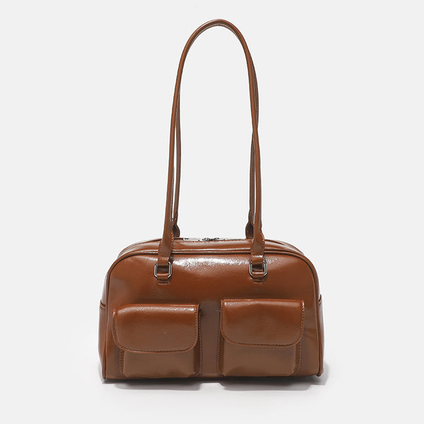 Structured glossy leather-look bowling shoulder bag with two front flap pockets, top zip closure, and long double shoulder
