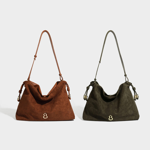 Suede-look drawstring shoulder bag in brown with smooth trim, knotted bead drawstring closure, slim adjustable strap, and