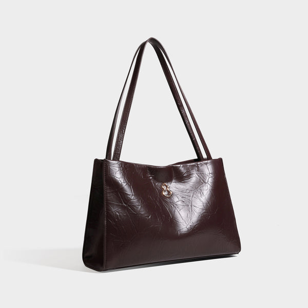 Strukturierte rechteckige Schultertasche im Tote-Stil mit glänzender, geknautschter Oberfläche in Lederoptik, langen Doppelriemen und Emblem in Goldoptik
