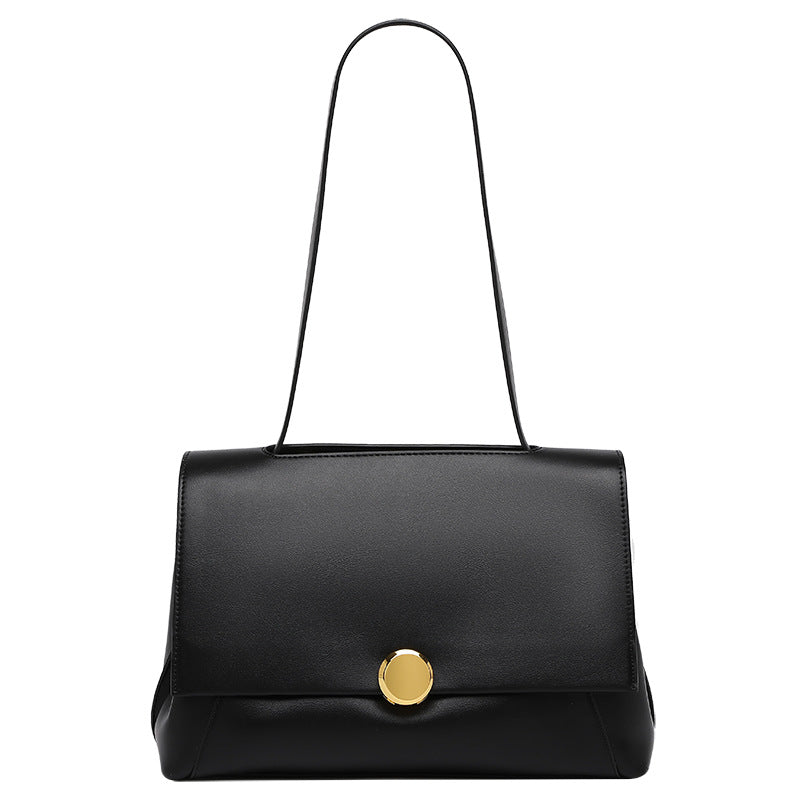 Structured flap shoulder bag with round gold-tone clasp and long flat strap in smooth matte leather-look finish, detail view