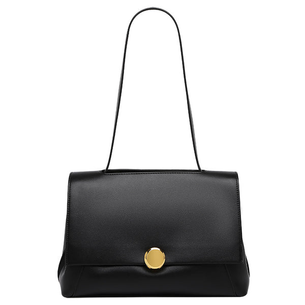 Structured flap shoulder bag with round gold-tone clasp and long flat strap in smooth matte leather-look finish, detail view