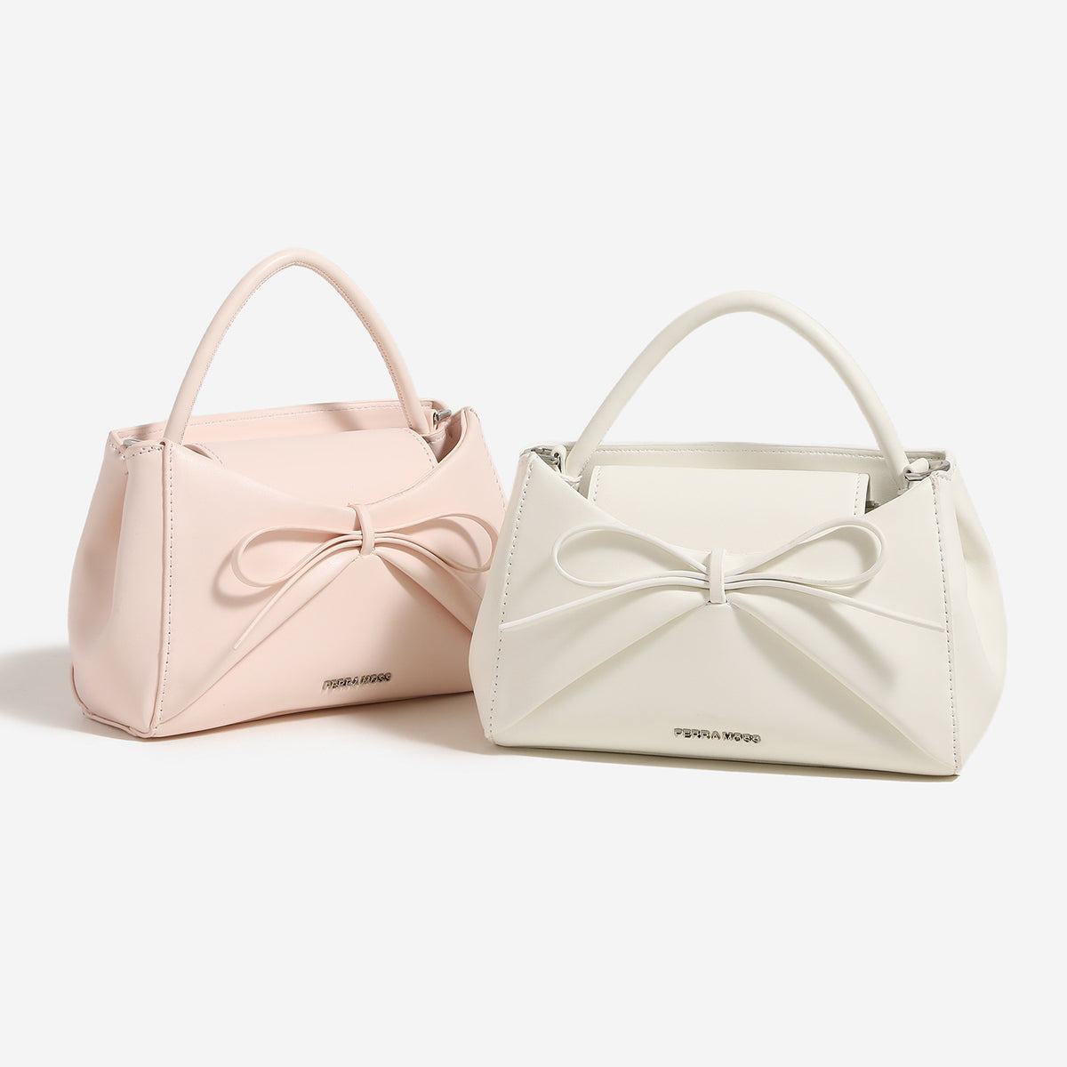 Small structured trapezoid handbag with a three-dimensional front bow, short top handle, and detachable shoulder strap